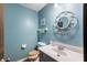 Stylish powder room featuring a modern vanity, decorative mirror, and soothing blue walls at 8306 Corkwood Dr, Indianapolis, IN 46227