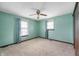 A clean bedroom with two windows, a ceiling fan, and carpet, ready for personalization at 8306 Corkwood Dr, Indianapolis, IN 46227