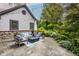 An inviting backyard patio with stone pavers, a fire pit, comfortable seating, and lush landscaping at 8651 Emerald Ln, Indianapolis, IN 46260