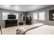 Comfortable bedroom featuring plush carpet, dark wood furniture, and three windows at 8651 Emerald Ln, Indianapolis, IN 46260