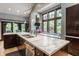 Large kitchen island with a breakfast bar and stainless steel sink, surrounded by dark wood cabinets at 8651 Emerald Ln, Indianapolis, IN 46260