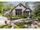 Beautiful landscaping showcasing a water feature, flowering plants, and a walkway to the front entrance at 8651 Emerald Ln, Indianapolis, IN 46260