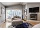 Cozy living room featuring a fireplace, a comfortable chair, and lots of natural light at 8651 Emerald Ln, Indianapolis, IN 46260