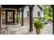 Covered outdoor patio featuring stone columns, gray tile, potted plants, and cozy outdoor furniture at 8651 Emerald Ln, Indianapolis, IN 46260