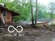 Exterior view showing house with damaged surroundings and detached garage at 8803 S Sleepy Hollow Rd, Waldron, IN 46182
