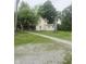 Charming two-story home featuring a quaint porch and a long driveway leading to the property at 9024 W Mooresville Rd, Indianapolis, IN 46113