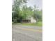 Traditional two-story home with a brick porch and mature trees providing shade and curb appeal at 9024 W Mooresville Rd, Indianapolis, IN 46113