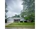 Charming single-story home with well-manicured lawn and mature trees on an overcast day at 907 Corey Ln, Plainfield, IN 46168