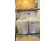 Functional laundry area with a modern, white washer and dryer set and wood cabinets for ample storage at 907 Corey Ln, Plainfield, IN 46168