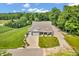 Aerial view showcasing a home with a three-car garage, set on a spacious lot with lush greenery at 9231 E Poynter Dr, Morgantown, IN 46160