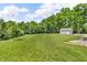Spacious, well-manicured backyard with storage shed, surrounded by mature trees, under a sunny sky at 9231 E Poynter Dr, Morgantown, IN 46160