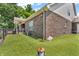 Well-maintained backyard with artificial turf, brick exterior, a dog run, and partial fence at 9231 E Poynter Dr, Morgantown, IN 46160