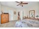 Cozy bedroom featuring neutral walls, ceiling fan, dresser and a view into the hallway at 9231 E Poynter Dr, Morgantown, IN 46160