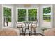 Bright breakfast nook with a glass-top table and bar stools, offering a view of the wooded area at 9231 E Poynter Dr, Morgantown, IN 46160