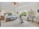 Bright main bedroom with tray ceilings, ceiling fan, and large window overlooking the backyard at 9231 E Poynter Dr, Morgantown, IN 46160