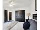 Bright bedroom featuring a ceiling fan, black closet doors, and neutral walls at 9508 Oakley Dr, Indianapolis, IN 46260