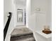 Carpeted hallway with staircase, white walls, and a decorative mirror at 9508 Oakley Dr, Indianapolis, IN 46260