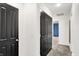 Hallway with black doors and neutral carpet leading to a room with blue curtains at 9508 Oakley Dr, Indianapolis, IN 46260
