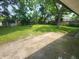 Lush backyard featuring mature trees, green grass, and a weathered concrete patio for outdoor enjoyment at 9526 Burrwood Ct, Indianapolis, IN 46235