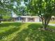 Charming single-story home with a manicured lawn and mature trees providing shade at 9526 Burrwood Ct, Indianapolis, IN 46235