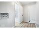 Hallway with wood floors leads to a bathroom with marble tile and white fixtures at 9526 Burrwood Ct, Indianapolis, IN 46235