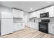 Updated kitchen features white cabinets, stainless steel appliances, and wood-look vinyl flooring at 9526 Burrwood Ct, Indianapolis, IN 46235