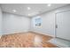 Bright living room featuring hardwood floors, a large window, and a white entry door at 9526 Burrwood Ct, Indianapolis, IN 46235