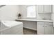 Bright laundry room with white cabinets, sink, countertop, and window with blinds at 9678 Winter Way, Zionsville, IN 46077