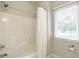 Bright bathroom shower with white shower curtain and window with blinds at 9678 Winter Way, Zionsville, IN 46077