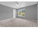 Sunlit bedroom boasts neutral carpeting and a ceiling fan at 10187 Yosemite Ln, Indianapolis, IN 46234