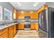 Charming kitchen featuring wood cabinets, stainless steel appliances, and modern refrigerator at 10187 Yosemite Ln, Indianapolis, IN 46234