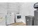 Laundry room featuring a washer, dryer, storage shelves, and a water conditioning system at 10187 Yosemite Ln, Indianapolis, IN 46234