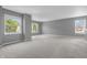 Spacious living room with neutral carpeting, three windows, and bright gray walls at 10187 Yosemite Ln, Indianapolis, IN 46234