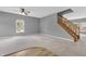 Open-concept living room featuring soft carpet, neutral gray walls, and a wood staircase at 10187 Yosemite Ln, Indianapolis, IN 46234