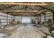 View of large barn interior with metal frame and gravel floor, providing potential for versatile storage or workspace at 10965 W Base Line Rd, Jamestown, IN 46147