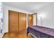 This bedroom features hardwood floors, closet, and a decorative purple blanket on the bed at 10965 W Base Line Rd, Jamestown, IN 46147