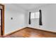 Empty bedroom with hardwood floors, and natural light from a window dressed with curtains at 10965 W Base Line Rd, Jamestown, IN 46147