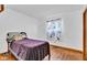 Bedroom with neutral walls, wood floors, floral curtains, and small bed at 10965 W Base Line Rd, Jamestown, IN 46147