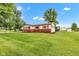 Charming single-story home with red accents surrounded by a lush green lawn, creating an inviting curb appeal at 10965 W Base Line Rd, Jamestown, IN 46147