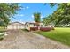 Inviting home exterior featuring a detached garage, gravel driveway, and lush front lawn at 10965 W Base Line Rd, Jamestown, IN 46147