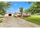 Inviting home exterior featuring a detached garage, gravel driveway, and lush front lawn at 10965 W Base Line Rd, Jamestown, IN 46147