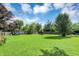 Open backyard featuring play equipment, a fire pit, and lush greenery at 12606 Markay Dr, Fishers, IN 46038