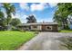 Charming single-story home featuring combination brick and wood facade, gravel drive, and lush landscaping at 12606 Markay Dr, Fishers, IN 46038
