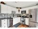 Modern kitchen features white cabinets, stainless steel appliances, dark countertops, and a mosaic tile backsplash at 12606 Markay Dr, Fishers, IN 46038