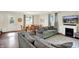 Comfortable living room featuring two gray sofas, hardwood floors, fireplace, and adjacent dining area at 12606 Markay Dr, Fishers, IN 46038