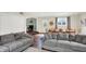 Open-concept living and dining area with comfortable sofas, wood flooring, and ample natural light at 12606 Markay Dr, Fishers, IN 46038