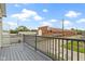 Balcony view showcases the gray painted deck overlooking a calm street, with a factory in the background at 134 N Elder Ave, Indianapolis, IN 46222