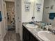 Bathroom featuring double sinks with granite countertops and dinosaur-themed decor at 1439 Silver Pine Ln, Sheridan, IN 46069