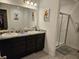 Bathroom featuring double sinks with dark cabinets, a shower with glass doors, and modern fixtures at 1439 Silver Pine Ln, Sheridan, IN 46069