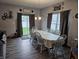 Bright dining room featuring a long table with white chairs, complemented by natural light from the sliding glass door at 1439 Silver Pine Ln, Sheridan, IN 46069